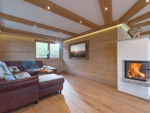 a living room with a couch and a fireplace at Panorama Lodge in Walchsee