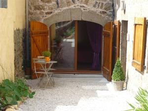 una entrada a un edificio con una puerta y una mesa en Chambre et Table d'hôtes Magaadjukalo, en Saint-Maurice-de-Lignon