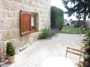 a stone building with a wooden door and a bench at Chambre et Table d'hôtes Magaadjukalo in Saint-Maurice-de-Lignon