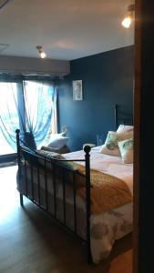1 dormitorio con 1 cama grande y paredes azules en Chambre et Table d'hôtes Magaadjukalo, en Saint-Maurice-de-Lignon