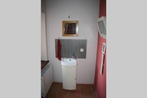 a small bathroom with a sink and a refrigerator at Studio privatif au centre de Lobbes in Lobbes