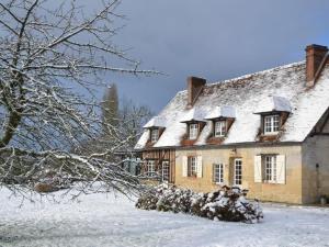 una casa con tetto coperto di neve in un cortile di Maison d'Hôtes la Bihorée a Lisieux