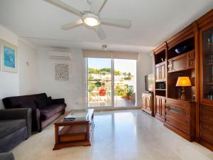 un soggiorno con divano e ventilatore a soffitto di Apartment Cala Manzanera-2 by Interhome a Calpe