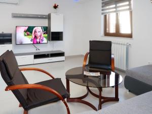 a living room with a table and chairs and a tv at Holiday Home Starci - LBN406 by Interhome in Labin