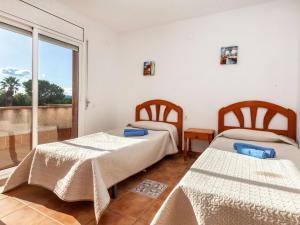 a bedroom with two beds and a balcony at Holiday Home Villa Santa Marta IV by Interhome in Les tres Cales
