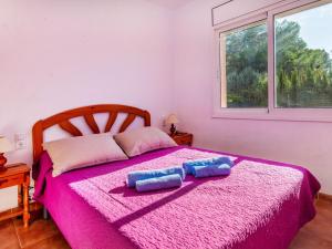 a bedroom with a pink bed with two pillows on it at Holiday Home Villa Santa Marta IV by Interhome in Les tres Cales