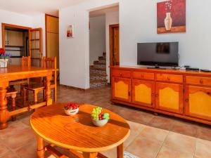 a living room with a table and a tv at Holiday Home Villa Santa Marta IV by Interhome in Les tres Cales