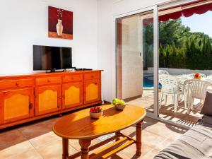 a living room with a tv and a table at Holiday Home Villa Santa Marta IV by Interhome in Les tres Cales