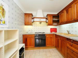 a kitchen with wooden cabinets and a stove top oven at Apartment Las Alondras-2 by Interhome in Roses
