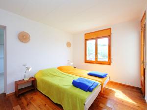 a bedroom with a bed with two blue pillows on it at Apartment Las Alondras-2 by Interhome in Roses +13 photos