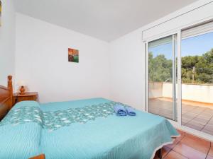 a bedroom with a bed and a large window at Villa Villa Mimosa II by Interhome in Les tres Cales