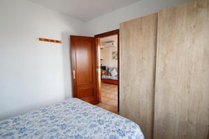ミアミ・プラトーヤにあるLas Marinas Cのベッドルーム1室(ベッド1台、木製クローゼット付)