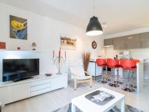 sala de estar con TV y sillas rojas en Apartment SYMAR by Interhome, en Roses