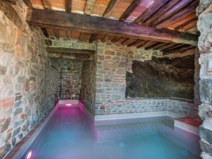 uma piscina interior num quarto com paredes de pedra com em Holiday Home Aurora by Interhome em Pescia