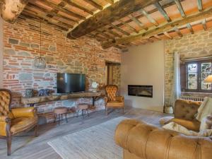 uma sala de estar com uma parede de tijolos e uma televisão em Holiday Home Aurora by Interhome em Pescia