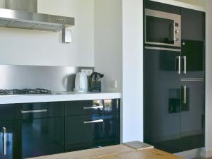 a kitchen with green cabinets and a microwave at Holiday Home Oesterdam Resort by Interhome in Tholen