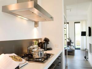 een keuken met een fornuis met potten en pannen erop bij Holiday Home Oesterdam Resort by Interhome in Tholen