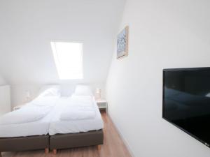 a bedroom with a bed and a flat screen tv at Holiday Home Oesterdam Resort-1 in Tholen