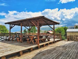 a wooden pavilion with tables on a wooden deck at Matsunoki in Karakol