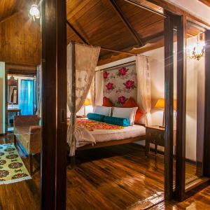a bedroom with a canopy bed in a room at Munjoh Ocean Resort in Havelock Island