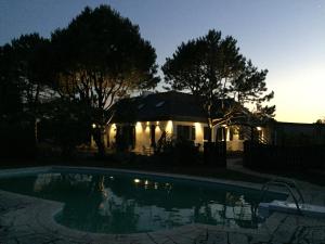une maison avec une piscine la nuit dans l'établissement La Dolce Vita, à Fouesnant