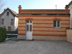 un edificio de ladrillo con una puerta blanca delante de una casa en Gîte La Tour Boileau, en Troyes