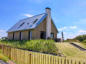 budynek z niebieskim dachem i płotem w obiekcie Holiday Home Oesterdam Resort-1 w mieście Tholen