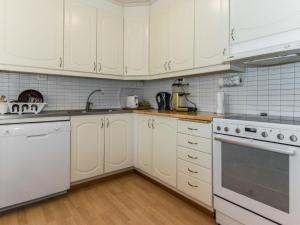 a kitchen with white cabinets and white appliances at Holiday Home Käpälämäki by Interhome in Somerniemi