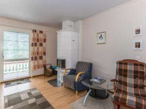 ein Wohnzimmer mit einem Sofa und einem Stuhl in der Unterkunft Holiday Home Käpälämäki by Interhome in Somerniemi