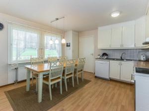 a kitchen with a table and chairs in a room at Holiday Home Käpälämäki by Interhome in Somerniemi