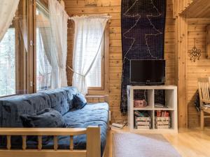 un soggiorno con divano blu e TV di Holiday Home Tunturipöllö - huoneisto 902 by Interhome ad Äkäslompolo