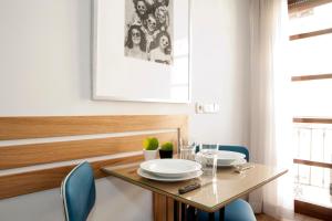 a dining room with a glass table and blue chairs at Apartamentos Sabinas Don Jaime in Zaragoza