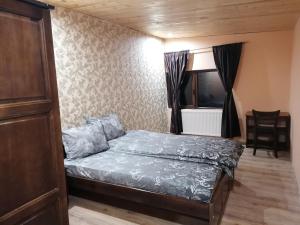 um pequeno quarto com uma cama e uma janela em Къща за гости ЕКО em Tsigov Chark