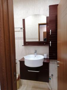 een badkamer met een wastafel en een spiegel bij Къща за гости ЕКО in Tsigov Chark