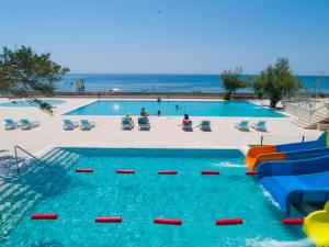 una piscina con un tobogán de agua y la playa en PEARL BEACH RESORT - Hills & Villas en Čanj