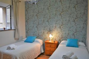 ムロスにあるApartamento Lindeのベッドルーム1室(青い枕のベッド2台付)