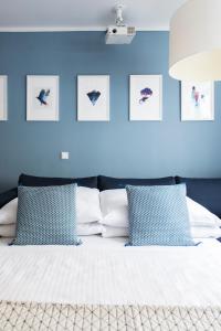 Schlafzimmer mit blauen Wänden und einem Bett mit blauen Kissen in der Unterkunft Mozart Apartment München in München