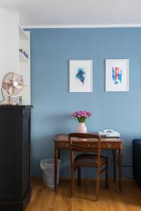 uma secretária com uma cadeira e uma parede azul em Mozart Apartment München em Munique