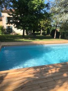 a large blue swimming pool in front of a house at la maison d'Obinat in Auzas
