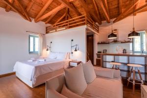 um quarto grande com uma cama e um sofá em Lithos Guesthouse Kardamili em Kardamili