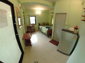 a small room with a bed and a bathroom at บ้านรักษ์วนา in Khao Kho