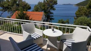 einen Tisch und Stühle auf einem Balkon mit Blick auf das Wasser in der Unterkunft Apartment Coraline on Korcula, seafront in Smokvica
