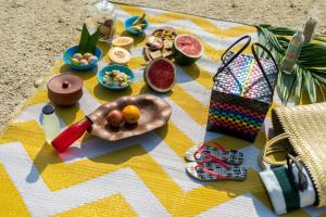 a picnic blanket with food and snacks on it at Munjoh Ocean Resort - Private Beachfront Luxury Retreat in Havelock in Havelock Island
