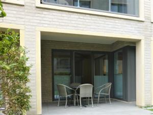 a patio with chairs and a table in a building at Apartment Oase am Meer, Am Alten Deich 18 in Dangast