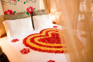 a heart made out of red flowers on a bed at Munjoh Ocean Resort - Private Beachfront Luxury Retreat in Havelock in Havelock Island