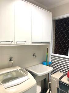 a bathroom with a sink and white cabinets at Spazio Felicita, Indaia, Bertioga, apartamento pé na areia in Bertioga