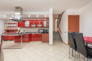 cocina con armarios rojos, mesa y sillas en Villa Sunshine, en Capitana