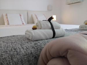 1 Schlafzimmer mit 2 Betten mit weißer Bettwäsche und einem katzenförmigen Kissen in der Unterkunft Casas Do Contrabando in Marvão
