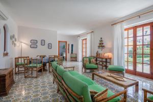 a living room with a green couch and a table at Villetta con Giardino esclusivo di 1000 mq, Piscina, Tennis, Calcio, Bocce in Forio d'Ischia