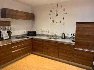 a kitchen with wooden cabinets and a sink at The Brolly Works in Birmingham